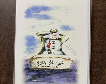 May include: A watercolor illustration of a snowman wearing a captain's hat and scarf, sitting in a boat with the words "Jolly old Soul" written on the side. The boat is floating on a blue and purple watercolor background.