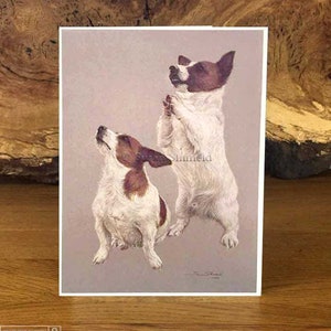 Puede incluir: Una ilustración vintage de dos Jack Russell Terriers, uno de pie sobre sus patas traseras con las patas levantadas en posición de oración, y el otro sentado con la cabeza echada hacia atrás y la boca abierta, como si cantara. El fondo es de color beige claro.