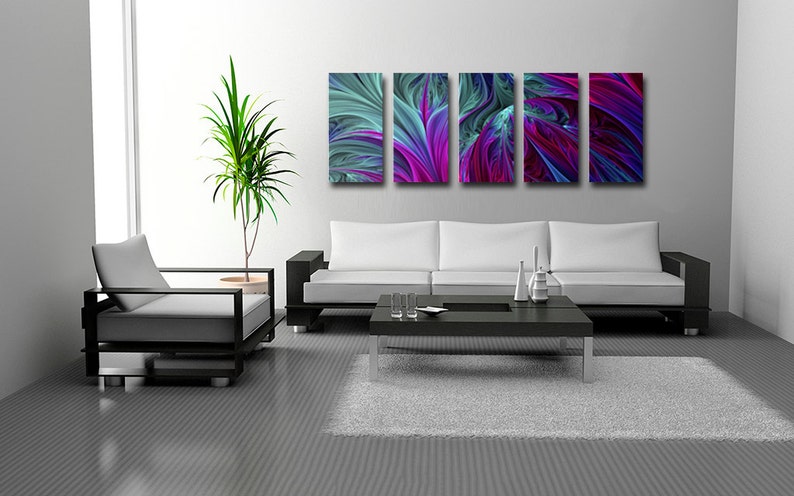 Może przedstawiać: Nowoczesne wnętrze salonu z białą sofą, czarnym stolikiem kawowym i szarym dywanem. Na ścianie znajduje się zestaw pięciu abstrakcyjnych grafik w odcieniach niebieskiego, fioletowego i zielonego.