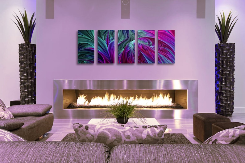 Może przedstawiać: Nowoczesny salon z kominkiem i zestawem czterech abstrakcyjnych grafik w odcieniach fioletu, błękitu i zieleni. Grafiki są ułożone w rzędzie nad kominkiem.