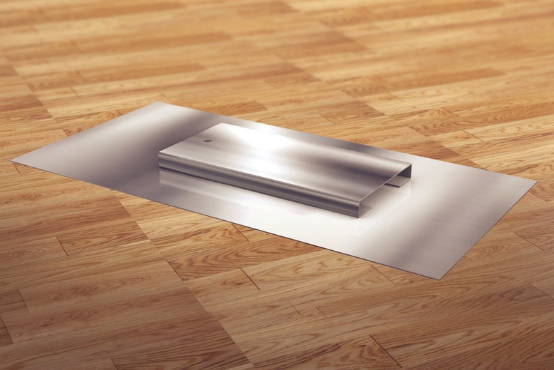 May include: A silver metal rectangular box sits on a silver metal surface. The surface is on a wooden floor.