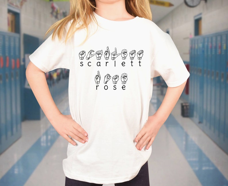 May include: White t-shirt with the name "Scarlett Rose" spelled out in British Sign Language.