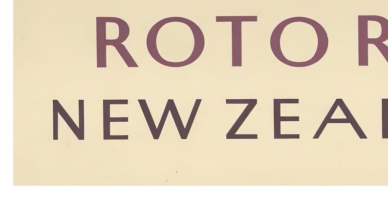 May include: A vintage sign with the text "Rotorua New Zealand" in a brown font on a light beige background.