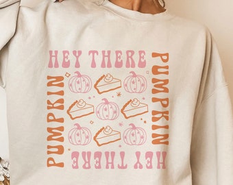 Könnte beinhalten: Ein weißer Pullover mit einem pinkfarbenen und orangenen Grafikdesign mit dem Text "Hey There Pumpkin" und Bildern von Kürbissen und Kürbiskuchen.