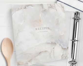May include: A white marble-patterned binder with the text "RECIPES" and "ELISE GIBSON" on the cover.