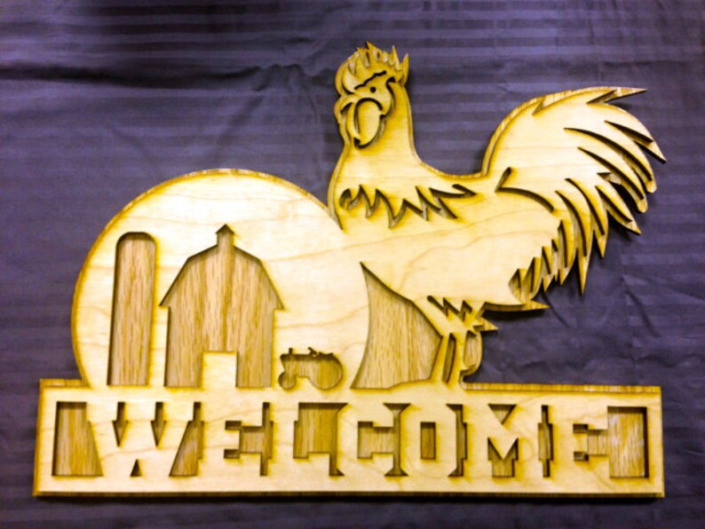 May include: Wooden welcome sign with a rooster silhouette, a barn, and a silo. The sign says "WELCOME" in a stylized font.