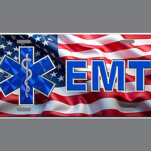 May include: A rectangular license plate featuring a waving American flag background. On the left is a blue Star of Life symbol with a silver serpent and staff. To the right, the letters EMT are printed in bold blue with a silver outline.