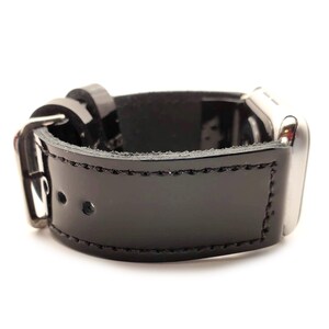 Puede incluir: Correa de reloj de cuero negro con hebilla y herrajes plateados. La correa es brillante y est&aacute; cosida en los bordes. La esfera del reloj es visible en el lado derecho.