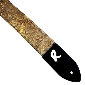 May include: Gold guitar strap with a black leather end and a white "R" on the end.