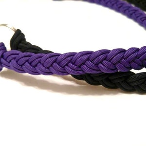 May include: A purple and black braided paracord keychain with a silver metal ring.