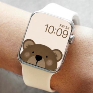 May include: A white silicone wristband watch with a brown bear face on the screen. The time is 10:09 and the date is FRI 23.