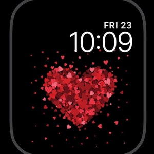 May include: A black Apple Watch face with a white digital clock displaying 10:09 and the date FRI 23. A large red heart made of smaller red hearts is in the center of the screen.
