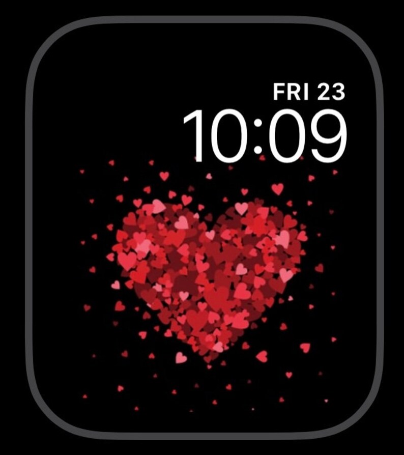 May include: A black Apple Watch face with a white digital clock displaying 10:09 and the date FRI 23. A large red heart made of smaller red hearts is in the center of the screen.