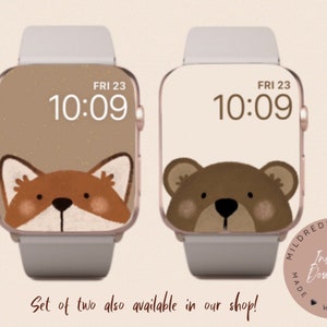 May include: Two Apple Watch faces with a brown background. The first face features a fox peeking out from the top of the screen. The second face features a bear peeking out from the top of the screen. Both faces display the time as 10:09 and the day as FRI 23.