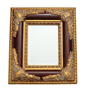 Könnte beinhalten: Ein verzierter Bilderrahmen in Gold und Braun mit einem dekorativen Design. Der Rahmen hat einen Spiegel im Inneren.