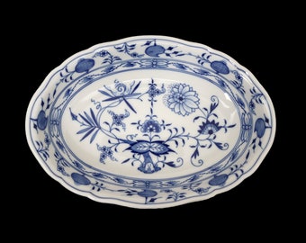 Op de afbeelding: Een witte ovale serveerschaal met een blauw en wit bloemenpatroon. De schaal heeft een gegolfde rand en is versierd met een herhalend bloemenontwerp.
