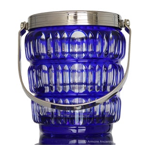 May include: A cobalt blue glass ice bucket with a silver rim and handle. The bucket has a textured, diamond-shaped pattern.