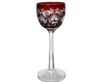 May include: A clear glass stemmed wine glass with a red, cut-glass bowl. The bowl has a geometric pattern.