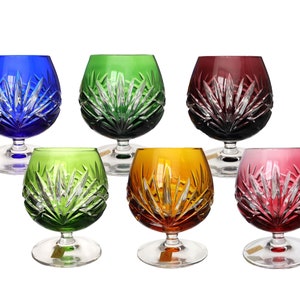 Può includere: Set di sei bicchieri di cristallo con gambo e design inciso. I bicchieri sono di vari colori: blu, verde, rosso, ambrato e rosa.