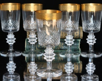 May include: Set of six clear glass wine glasses with gold rims and a diamond pattern. The glasses have a tall, slender stem and a round bowl.
