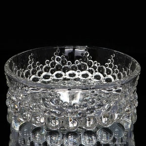 May include: A clear glass bowl with a textured bubble design. The bowl has a round shape and a wide rim.