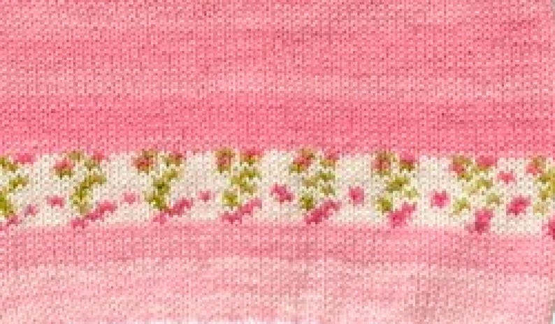 May include: A knitted fabric featuring a solid pink section and a horizontal band of white yarn decorated with a repeating pattern of small pink and green floral motifs. The texture shows consistent knit stitches throughout the entire surface.