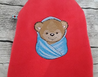 Wärmflasche mit roter Fleecehülle und gesticktem Teddybär