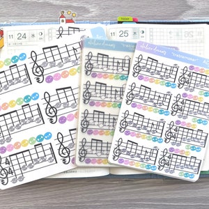 May include: A set of four clear sticker sheets with musical notes and treble clefs. The stickers are designed for use in a planner or journal. The stickers are labeled "treblemaker" and "ADS-017".