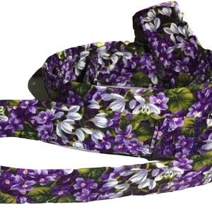May include: A purple and white floral dog leash with a silver clip.