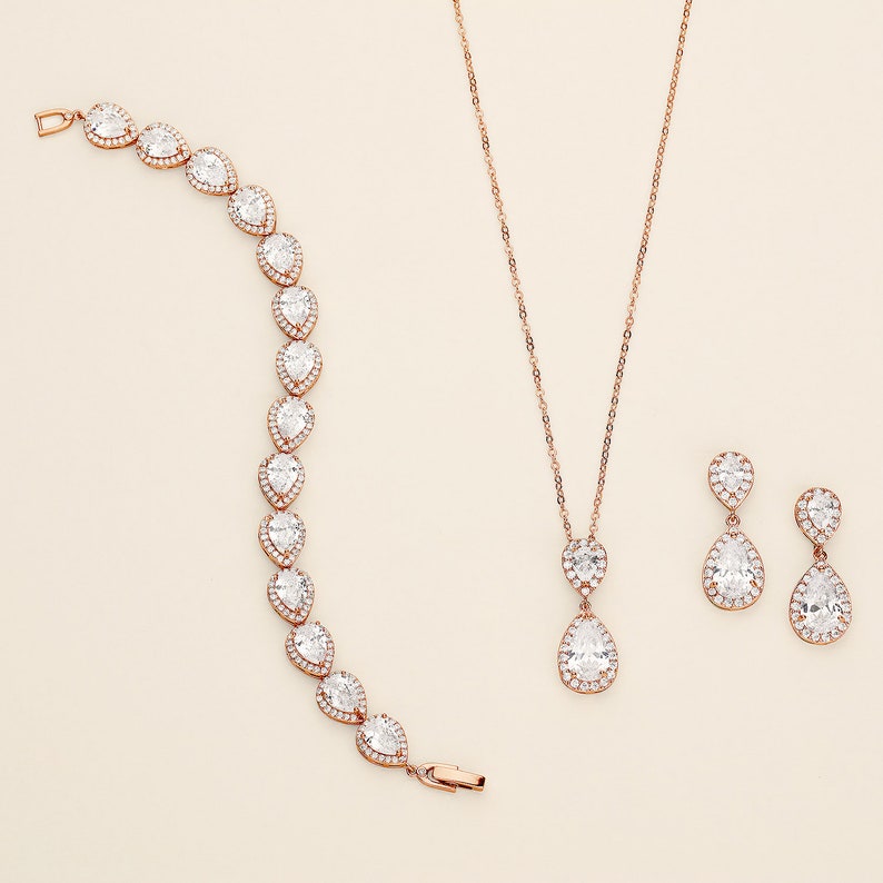 a necklace, bracelet, and earrings on a white surface