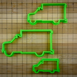May include: Three green plastic cookie cutters shaped like delivery vans of different sizes.