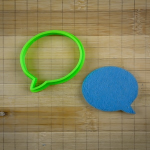 Peut inclure: Deux bulles de dialogue, l'une verte et l'autre bleue, sur un fond en bois.