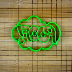 May include: Green plastic cookie cutter shaped like a speech bubble with the word "FOOD" inside.