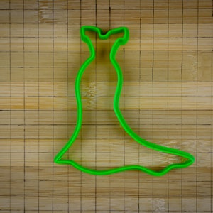 May include: Green plastic cookie cutter shaped like a dress.