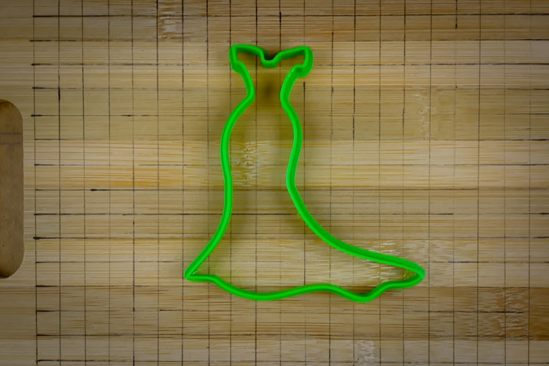 May include: Green plastic cookie cutter shaped like a dress.