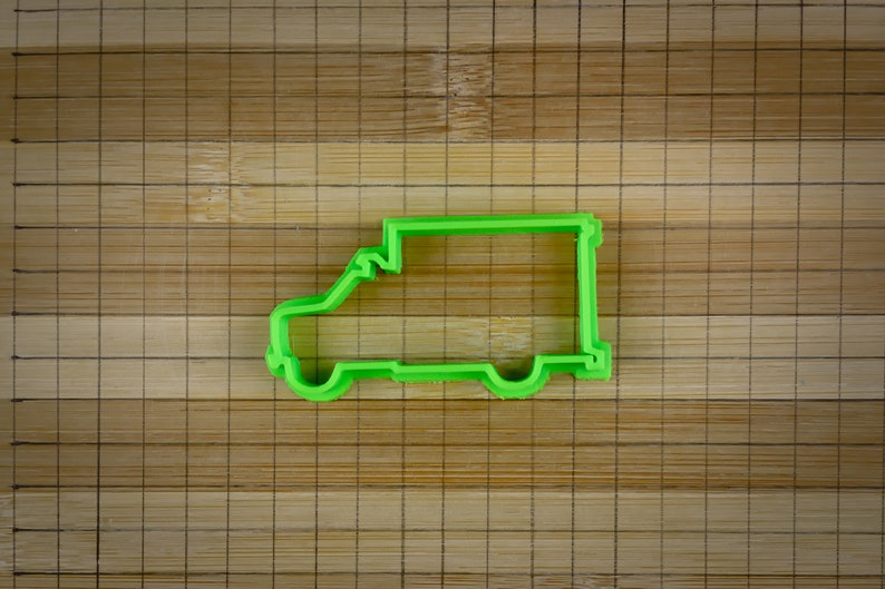 May include: Green plastic cookie cutter shaped like a delivery van.