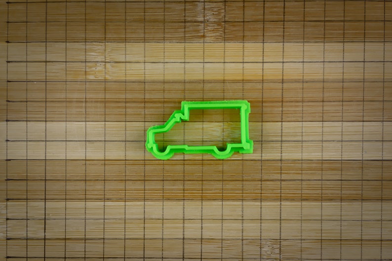 May include: Green plastic cookie cutter shaped like a delivery van.