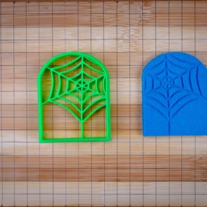 Könnte beinhalten: Zwei Ausstecher in Form eines Spinnennetzes. Einer ist grün und der andere ist blau.