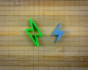 Puede incluir: Dos formas de rayos, una verde y otra azul, sobre un fondo de madera.