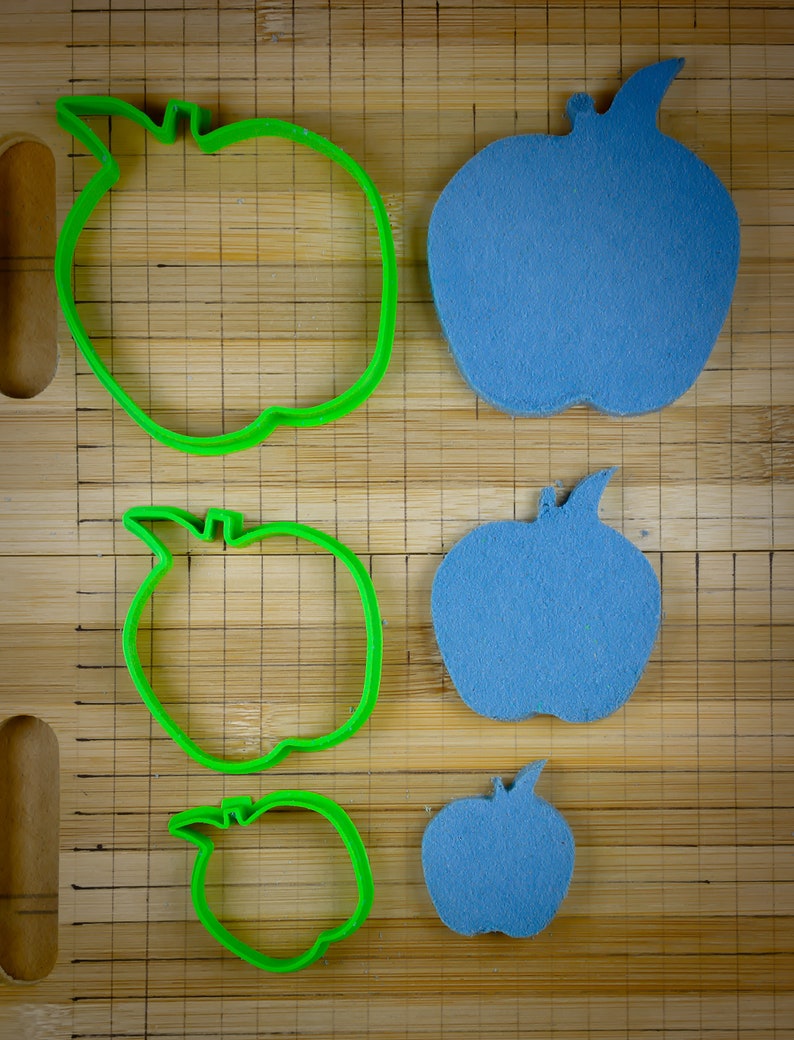 Peut inclure: Quatre emportes-pi&egrave;ces en forme de pomme, deux verts et deux bleus. Les emportes-pi&egrave;ces verts sont plus grands que les bleus.