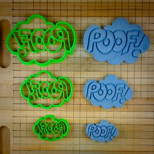 May include: Two sets of cookie cutters, one set is green and says "FOOF!" and the other set is blue and says "POOF!" The cutters are in different sizes.