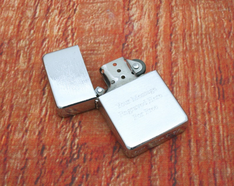 Puede incluir: Encendedor plateado con acabado cepillado y una inscripci&oacute;n personalizada que dice "Your Memory Forever In Our Hearts For You".