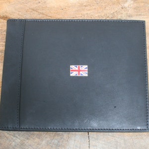 May include: Black leather photo album with a small Union Jack flag on the front.