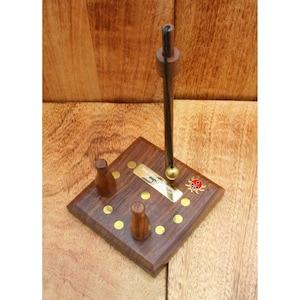 May include: Wooden pendulum with a black string and a brass ball. The pendulum is mounted on a square wooden base with brass accents and a ladybug design. The base has three wooden pegs and the text "Your Name Here" is engraved on a brass plate.
