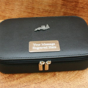 May include: Black zippered travel case with a silver metal truck charm and a silver metal plate that says "Your Message Engraved Here".