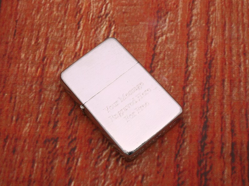 Puede incluir: Un encendedor plateado con un mensaje grabado que dice "Love Always, Remember Forever, You Are My Hero, Forever Yours".