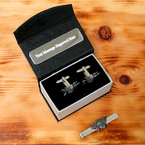 May include: A black gift box with a silver plate for engraving. The box contains a pair of silver cufflinks and a tie bar, both featuring a bee design. "Your Message Engraved Here" is printed on the silver plate.
