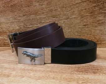 May include: Two leather belts with a silver buckle featuring a dinosaur design. The top belt is brown and the bottom belt is black.