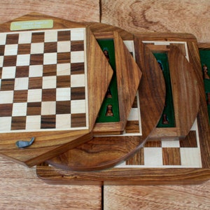 May include: A wooden chess set with a folding board. The board is made of light and dark wood and has a green felt lining. The chess pieces are made of wood and are in their starting positions.