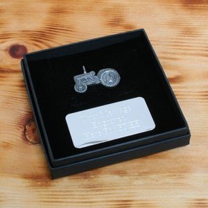 May include: A silver tractor figurine in a black gift box with a silver plaque that reads "To Dad 1976 - 2017 - Happy Birthday Dad - From Your Family".